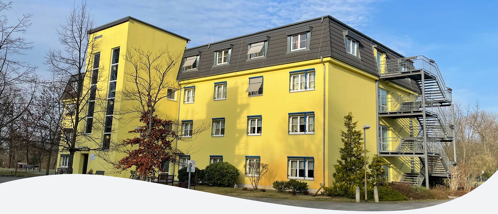 Seniorenzentrum Elsthal in Luckenwalde 4 stöckiges Gebäude mit gelber Fassade im Außenbereich